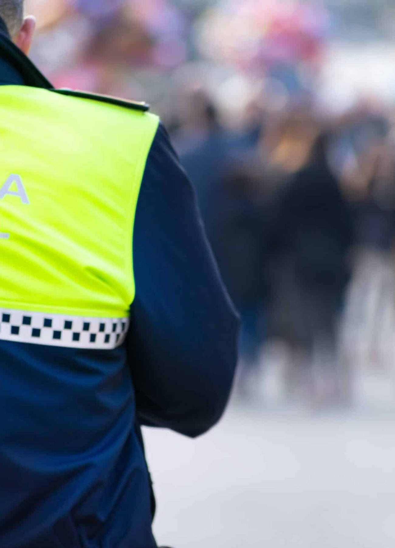 A closeup shot of a police officer with "local police" written on the uniform in Spanish